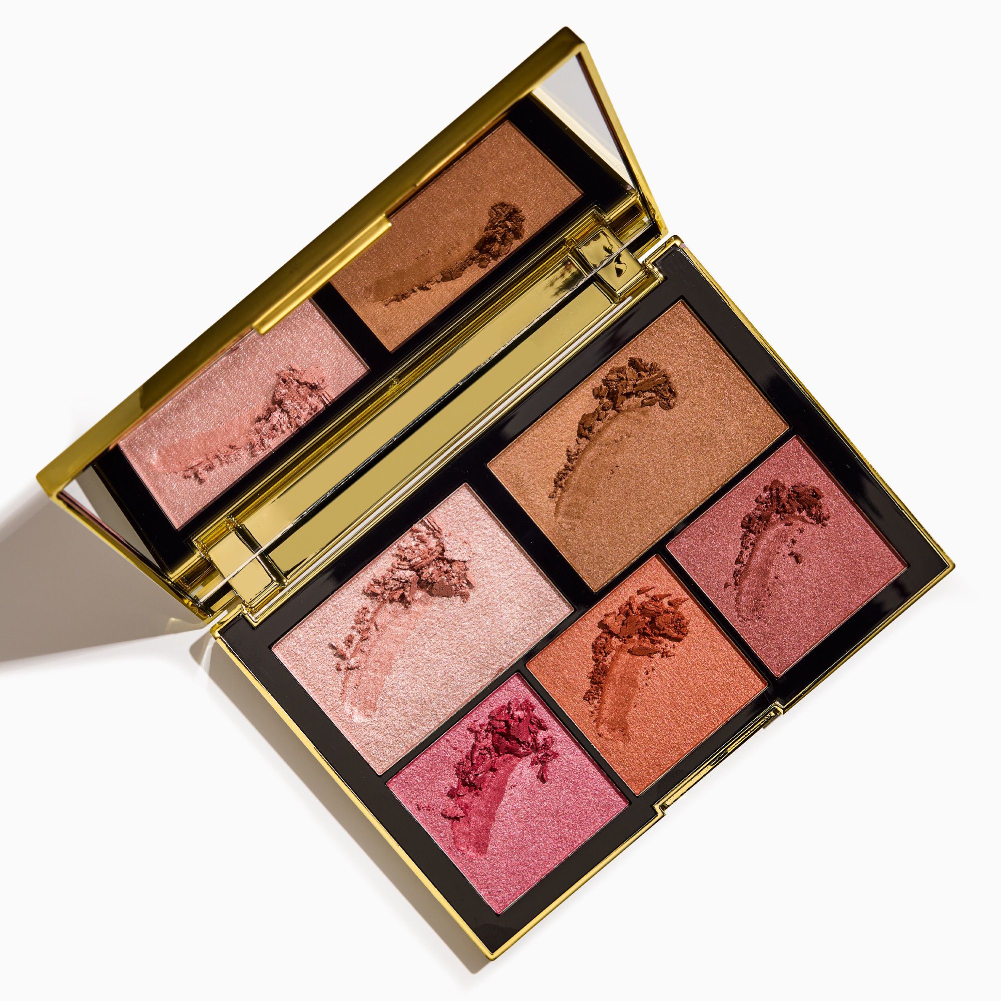 Makeup palette with gold casing and pink and brown shades on a white background