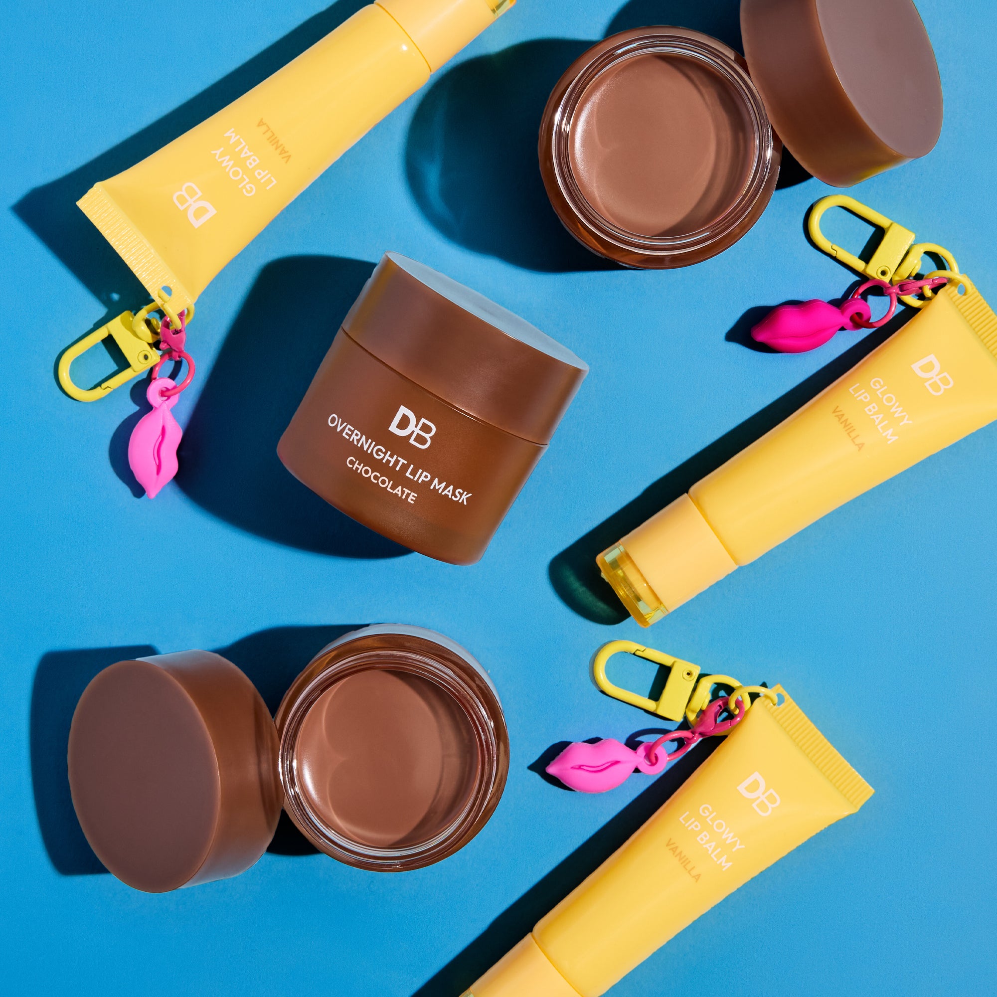 Chocolate lip mask jars and yellow containers on a blue background