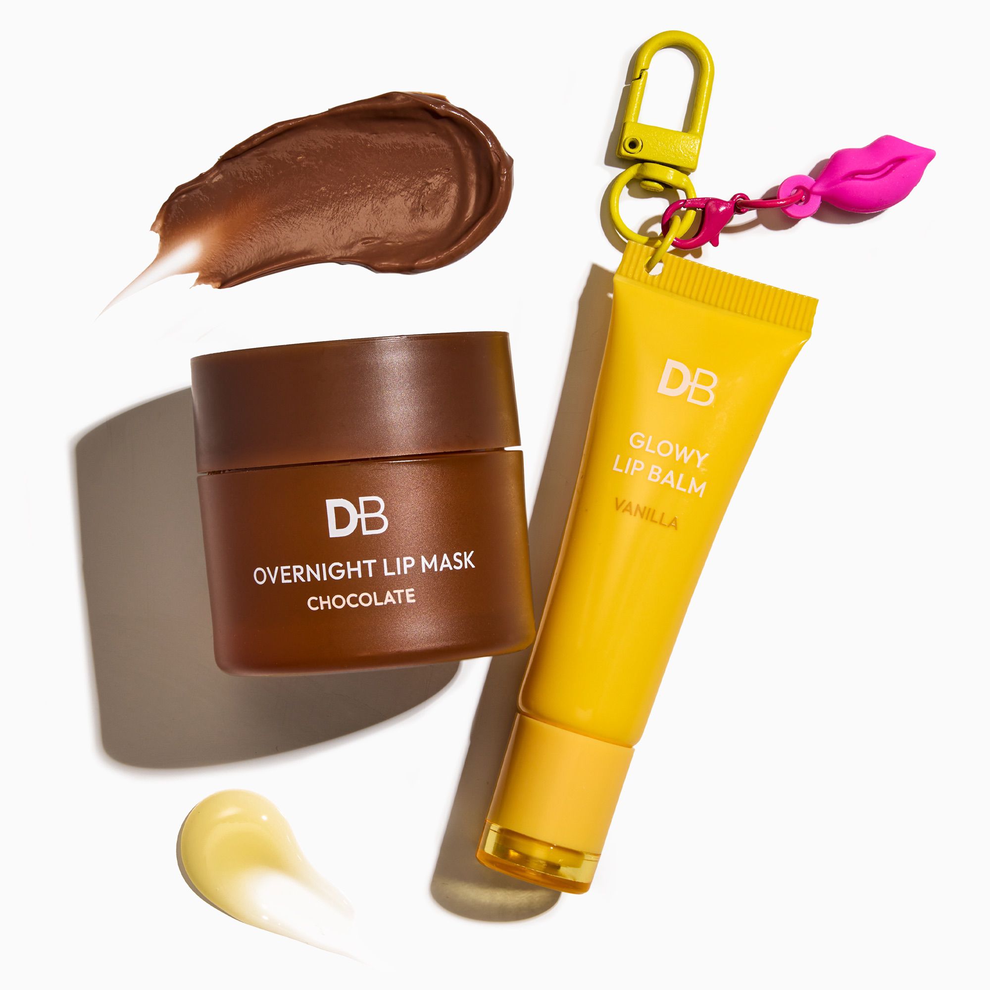 Chocolate lip mask jar and yellow lip balm tube with keychain on a white background
