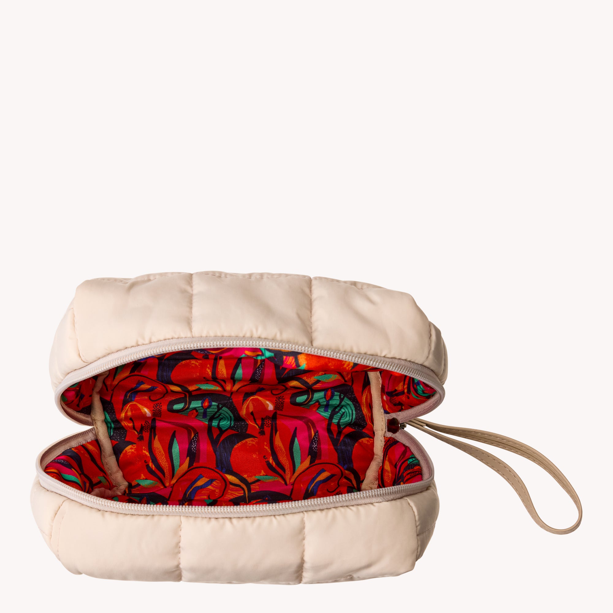Beige quilted pouch with colorful floral interior on a white background