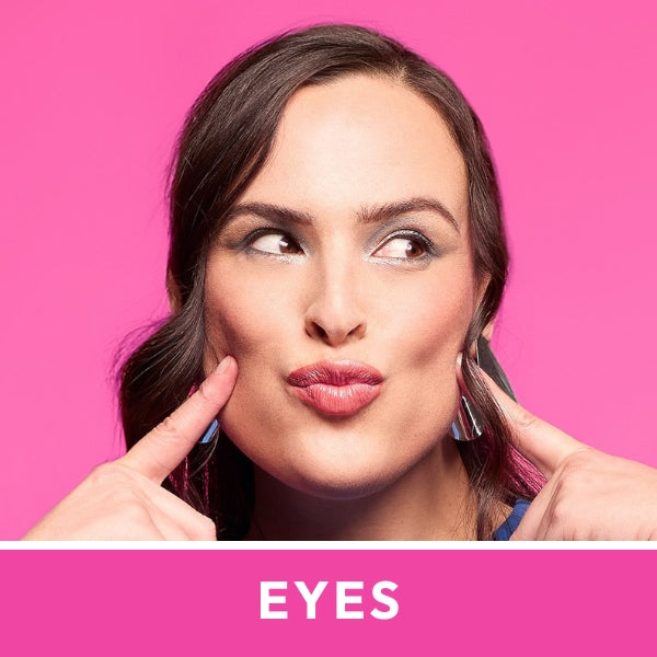 Woman posing against a bright pink background, wearing luxe jewellery. She points to her eyes, displaying elegant earrings. "EYES" text below.