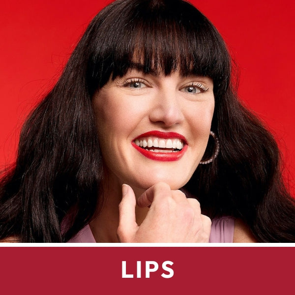 Woman with long black hair and bold red lips wearing hoop earrings, smiling against a vibrant red background. Text reads "LIPS".