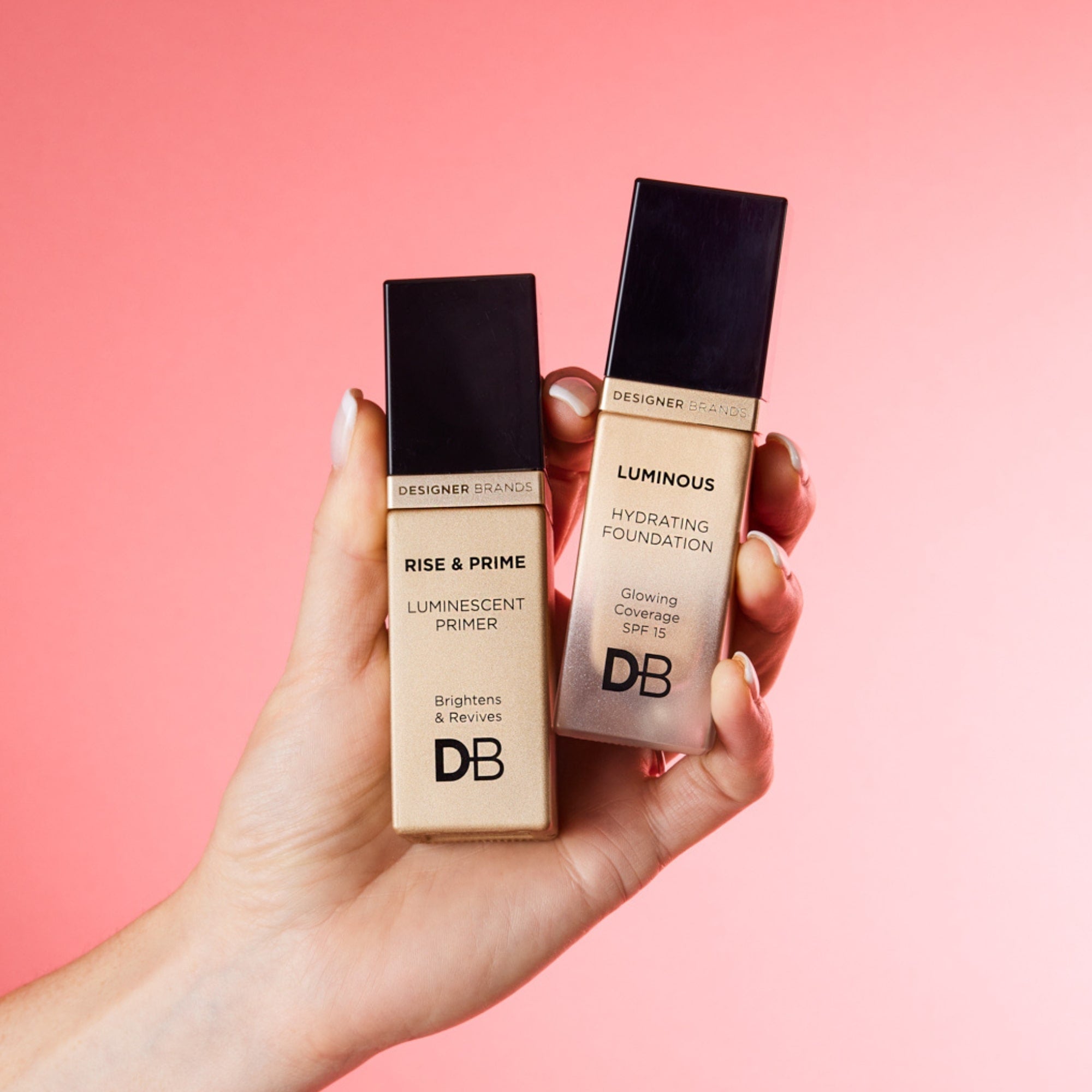 Two Designer Brands makeup bottles—Rise & Prime Luminescent Primer and Luminous Hydrating Foundation—held against a pink background.