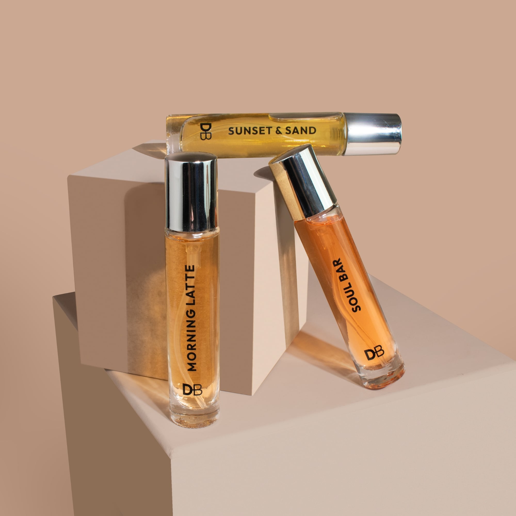 Three perfume bottles labeled 'Morning Latte', 'Sunset & Sand', and 'Soul Bar' on a beige background.