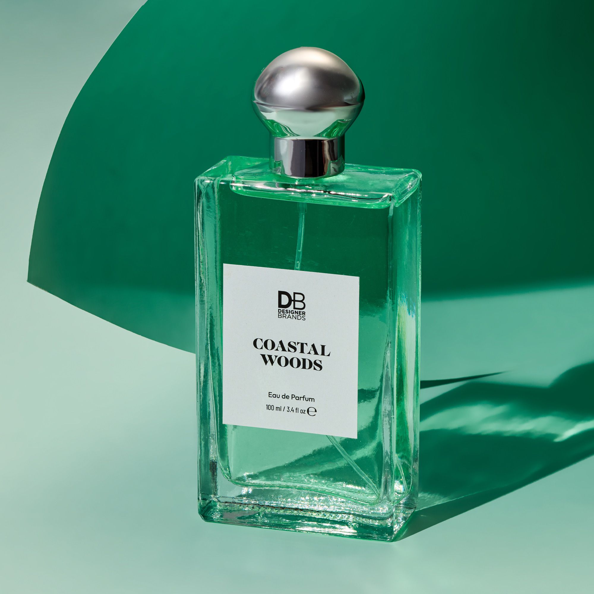 Perfume bottle labeled 'Coastal Woods' by DB Fragrances on a green background