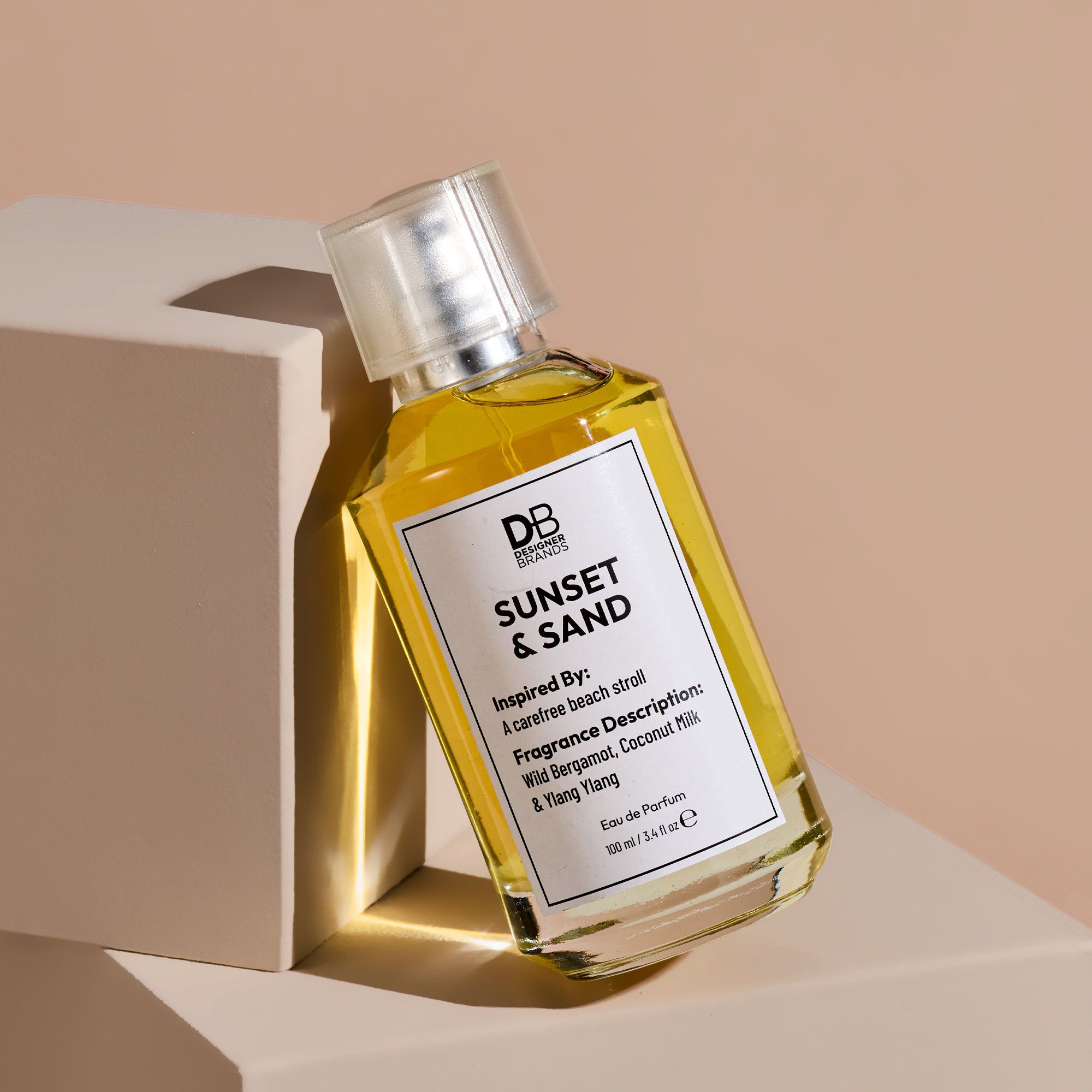 Perfume bottle labeled 'Sunset & Sand' by DB on a beige background