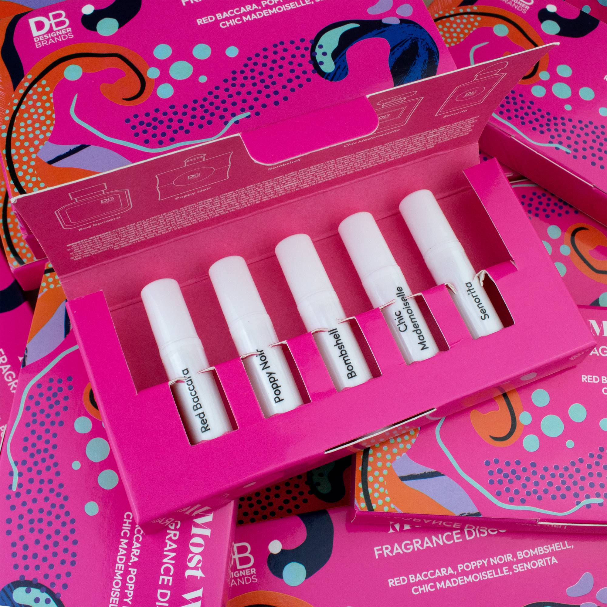 Set of lip glosses in a pink box with colorful packaging in the background
