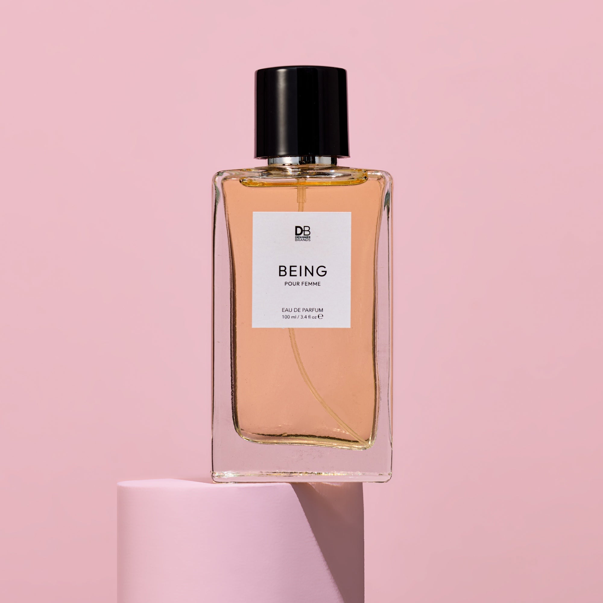 Perfume bottle labeled 'Being' on a pink background