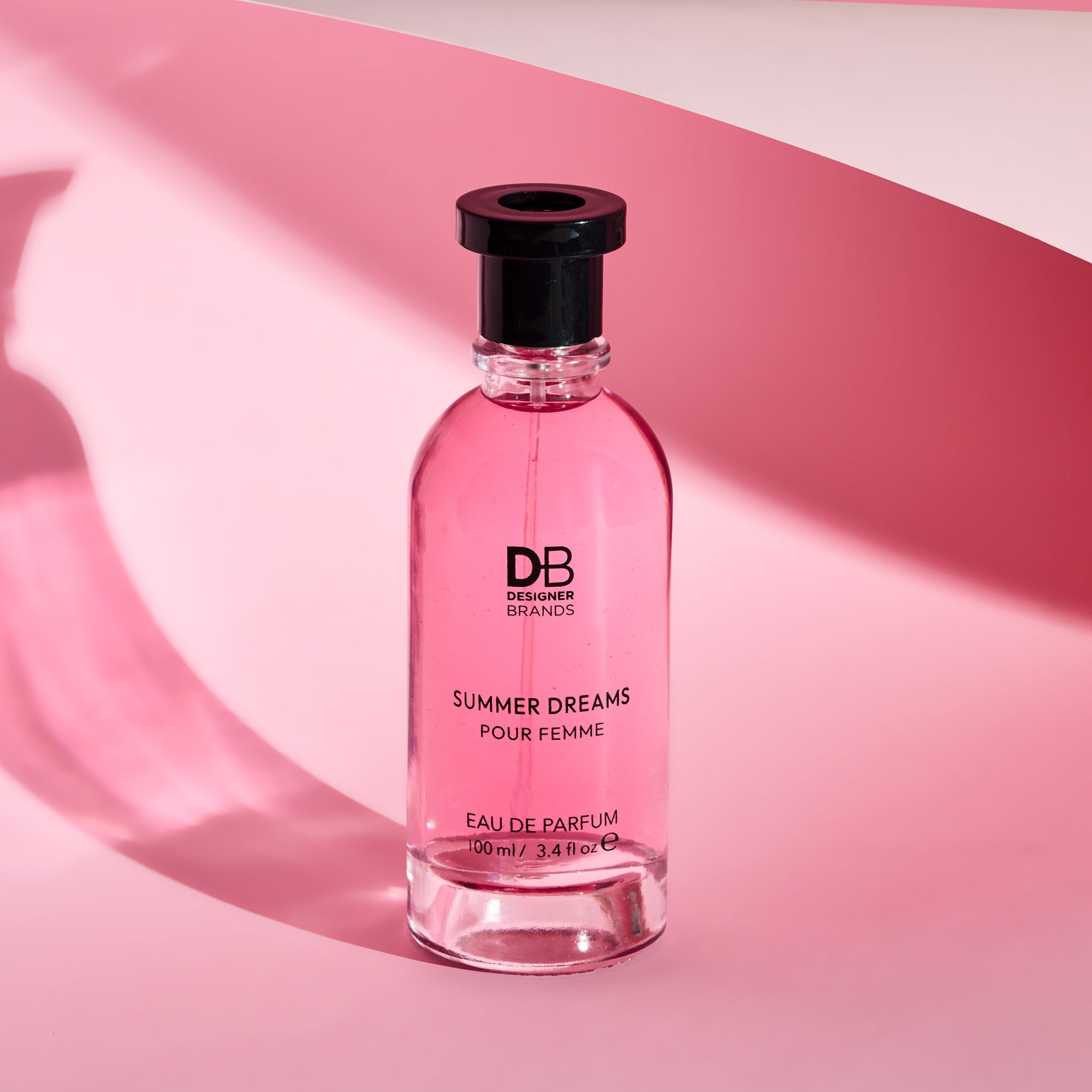 Pink perfume bottle labeled 'Summer Dreams' by Designer Brands on a pink background