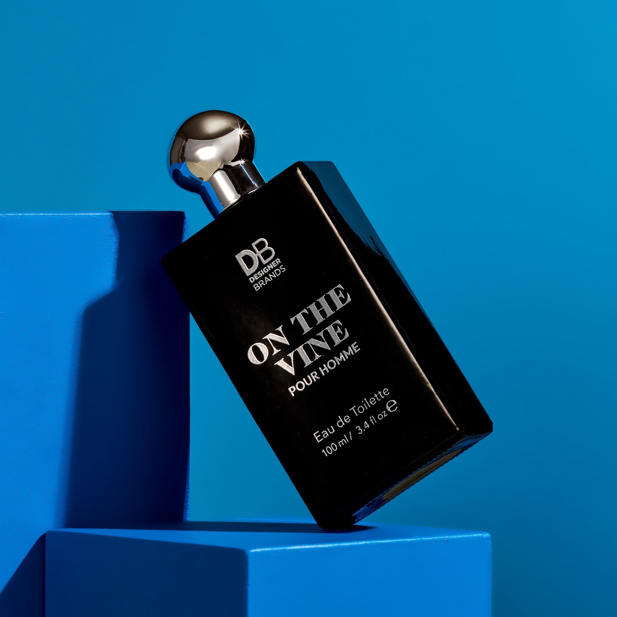 Perfume bottle labeled 'On The Vine Pour Homme' by DB on a blue background