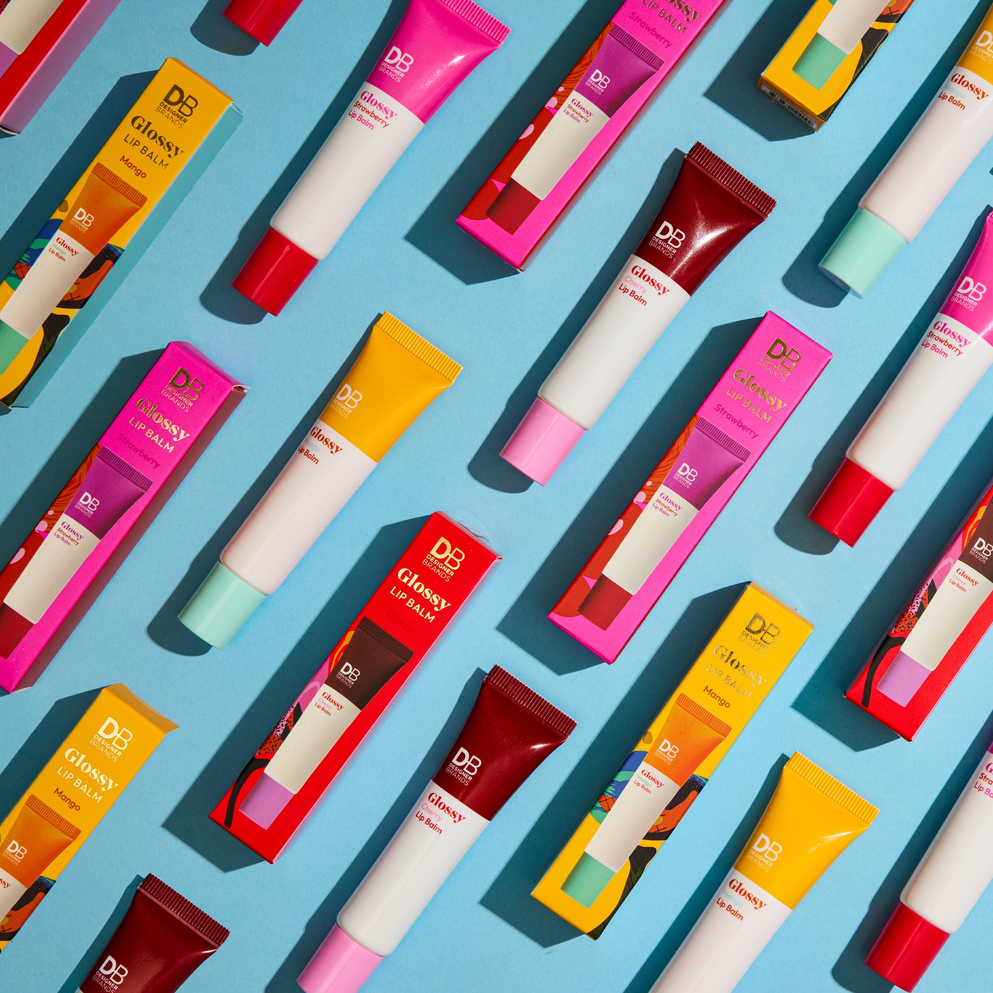 Pattern of colorful lip balm tubes on a blue background