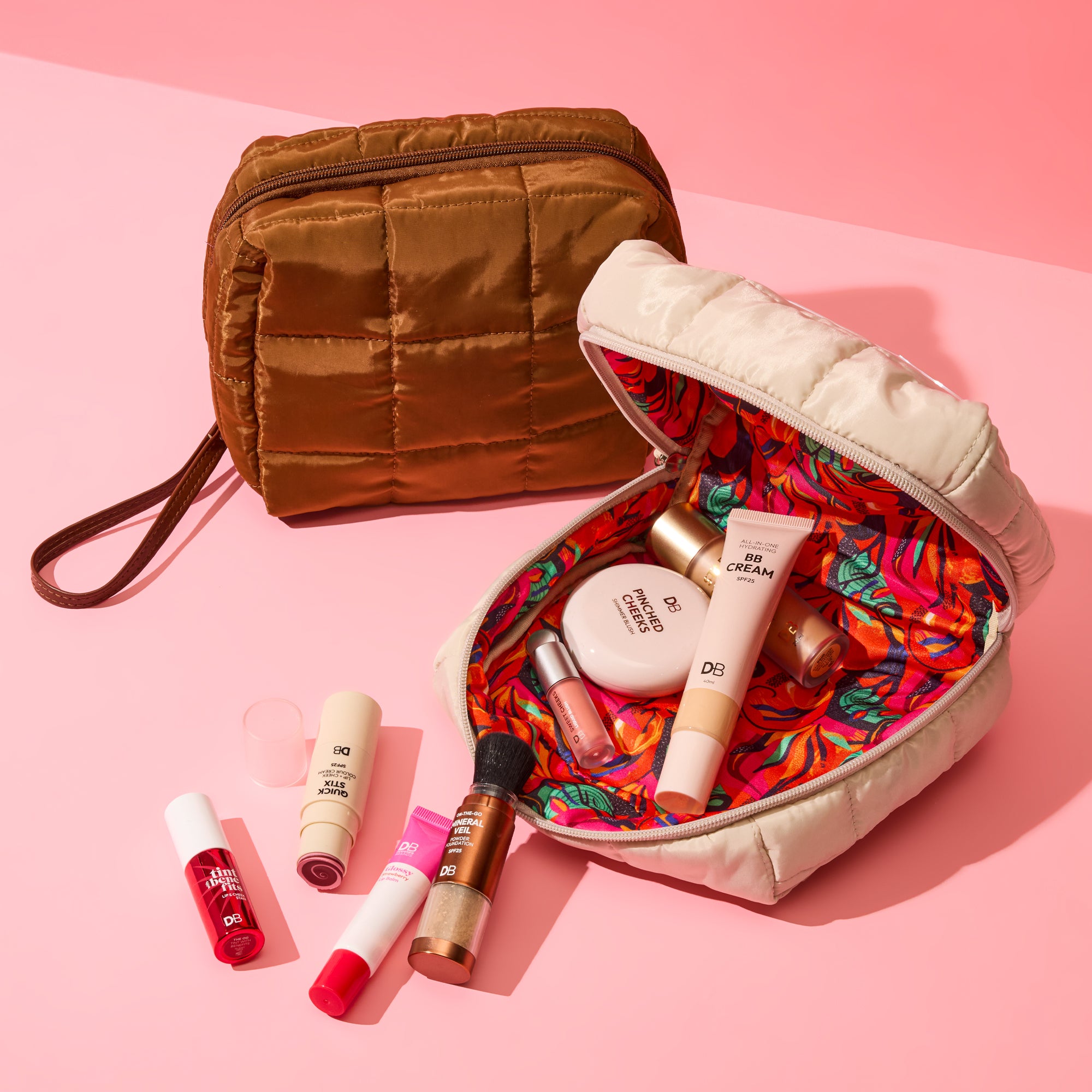 Makeup bag with colorful interior, makeup items on a pink background