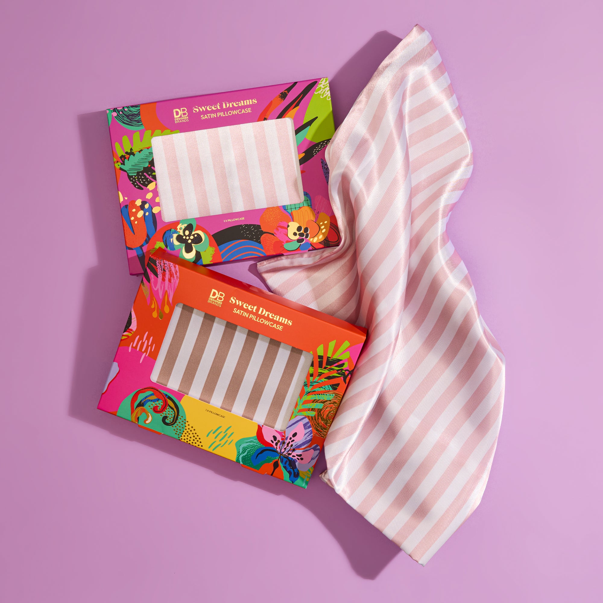 Striped pink silk pillowcase and eye mask in vibrant floral packaging. Set on a purple background, epitomising luxury bedtime essentials.