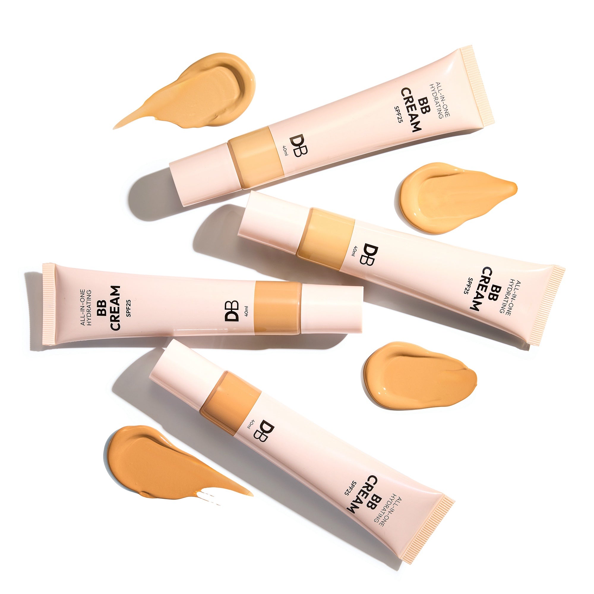 Multiple tubes of BB cream with applied samples on a white background