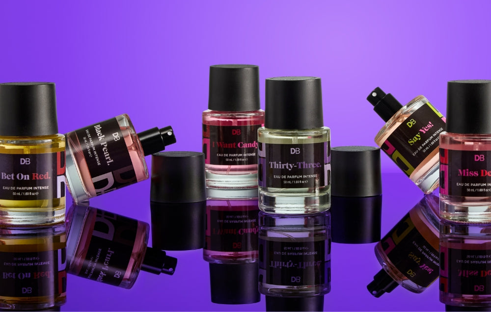 Collection of perfume bottles with visible labels on a purple background