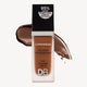 Longwear foundation bottle with "DB" logo, promising 24-hour full coverage and SPF 15. Features rich brown makeup swatch background.