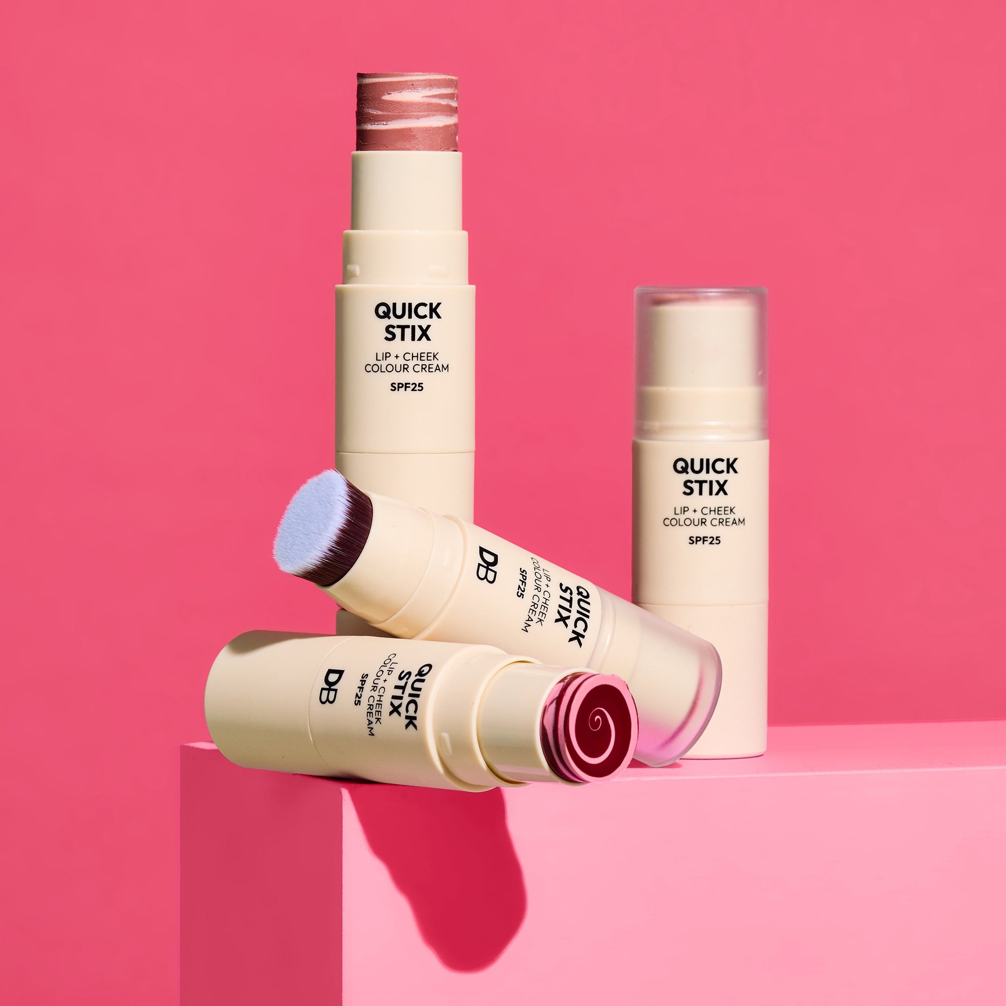 Quick Stix lip and cheek color cream on a pink background